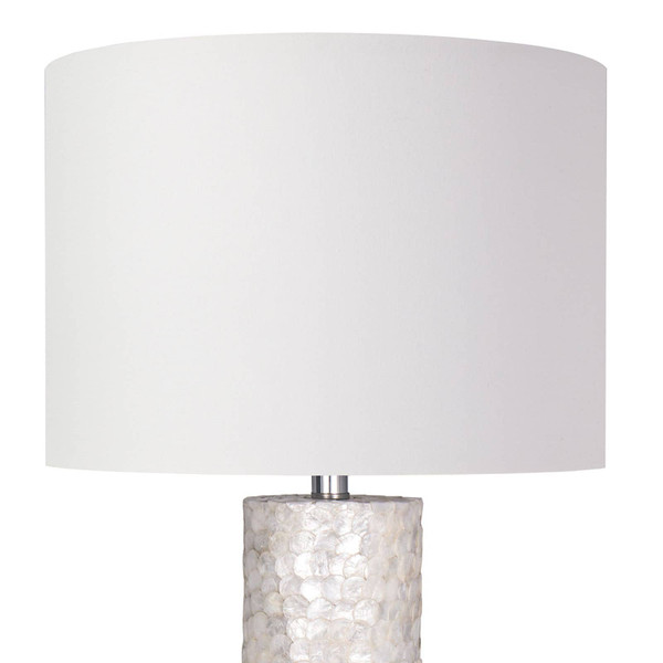 White linen shade of a scalloped capiz lamp